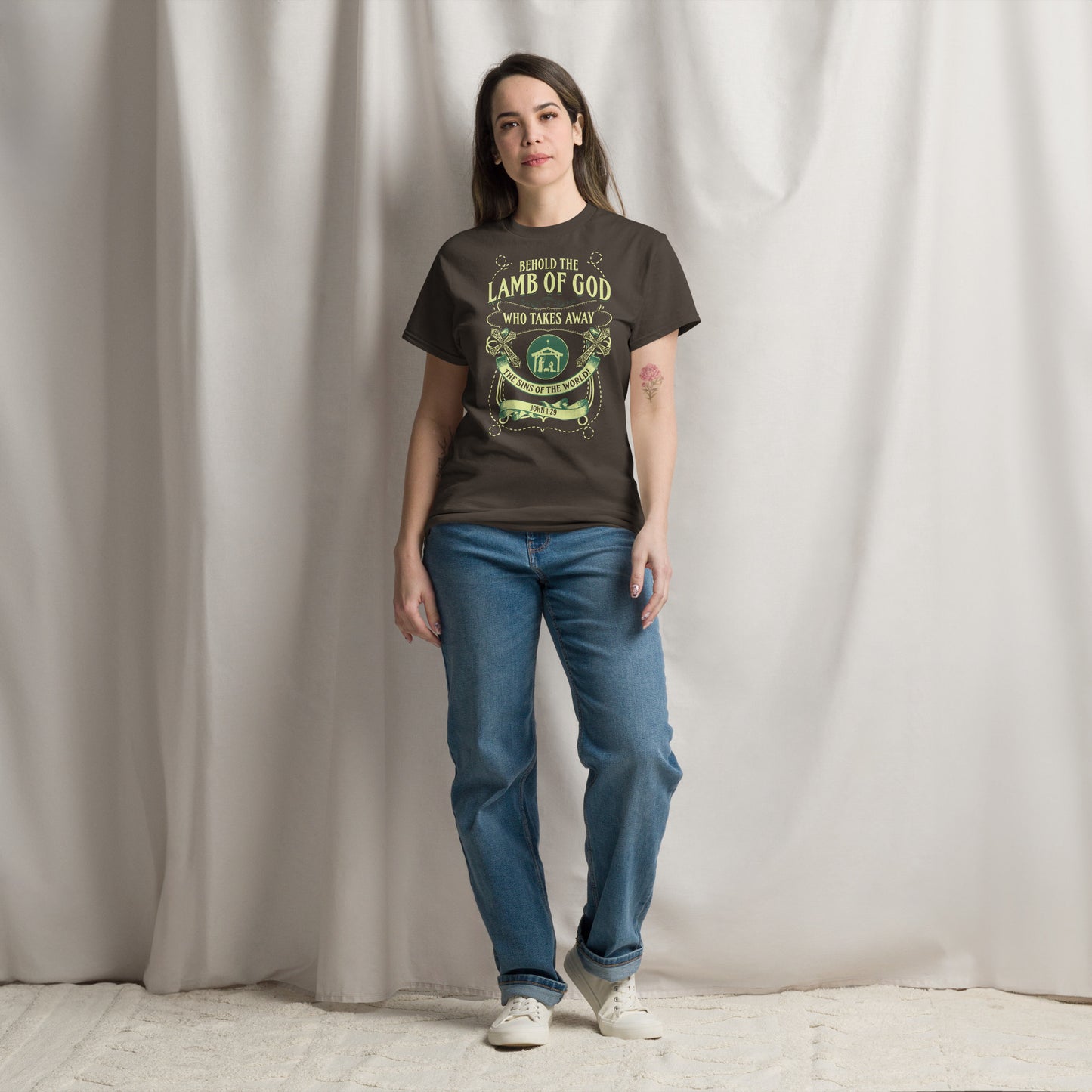 Woman wearing black Tees of Worship T-shirt with Behold the Lamb of God religious design and blue jeans