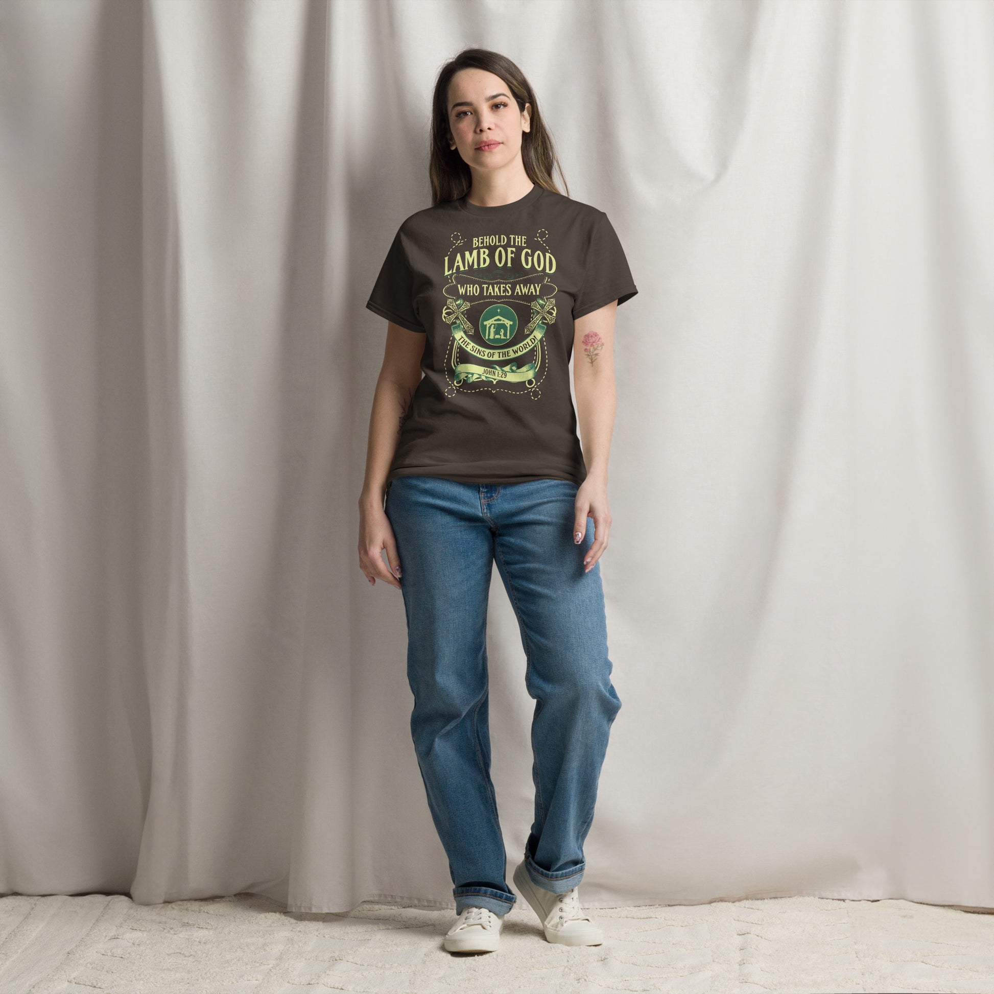 Woman wearing black Tees of Worship T-shirt with Behold the Lamb of God religious design and blue jeans